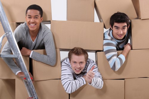 Local movers carrying furniture in a North London residential building